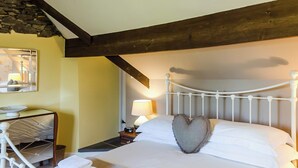A neatly made bed with a heart-shaped pillow, a bedside lamp, and a small table with a lamp. - 3 bedroom accommodation in Bowness-on-Windermere, near Windermere (Bowness-on-Windermere, near Windermere)