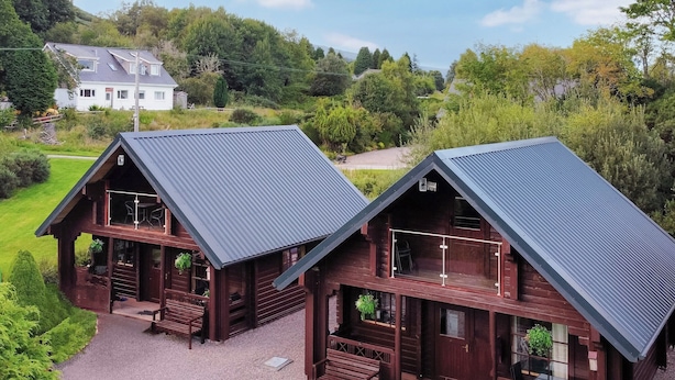 A wooden cabin with a gravel driveway and a small porch area. - 2 bedroom accommodation in Banavie, near Fort William (Banavie, near Fort William)
