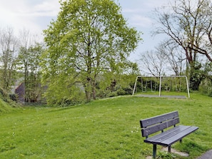 Un parc avec une balançoire et un banc.