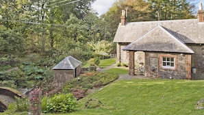 A stone house with a small garden and a pond. - Gardener's Cottage-UXT (Near Castle Douglas)