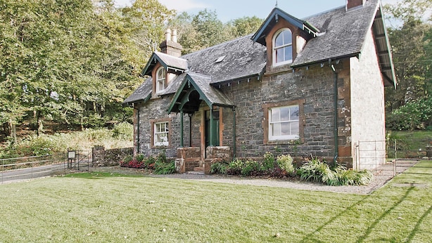 A stone house with a sloped roof, a chimney, and a well-maintained lawn. - Gardener's Cottage-UXT (Near Castle Douglas)