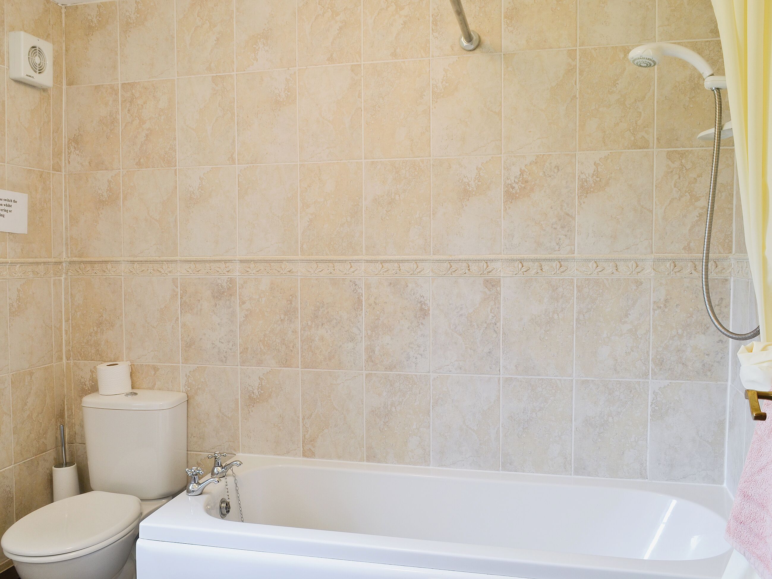 A bathroom with a bathtub, toilet, and shower.