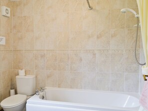 A bathroom with a bathtub, toilet, and shower.