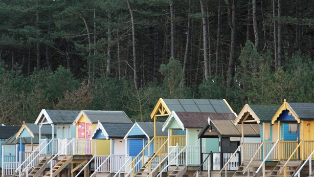 A row of beach huts with wooden stairs leading up to each one. - 4 bedroom accommodation in Wells-next-the-Sea (Wells-next-the-Sea)