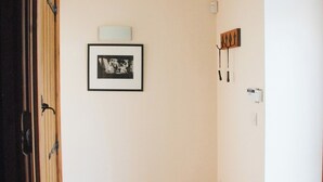 A hallway with a framed black and white photograph on the wall, a coat rack, and a light switch. - 1 bedroom accommodation in Fifehead Magdalen, near Gillingham (Fifehead Magdalen, near Gillingham)