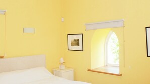 A room with a bed, a bedside table with a lamp, a framed picture on the wall, and a window with a view of greenery. - 1 bedroom accommodation in Fifehead Magdalen, near Gillingham (Fifehead Magdalen, near Gillingham)