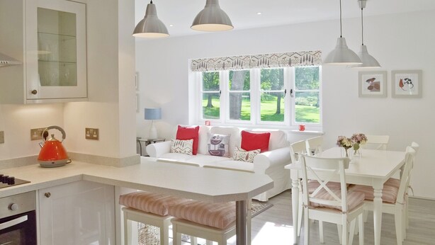 A modern kitchen with a central island, white cabinetry, and pendant lighting. - Wishing Well Cottage (Mathon, near Malvern)