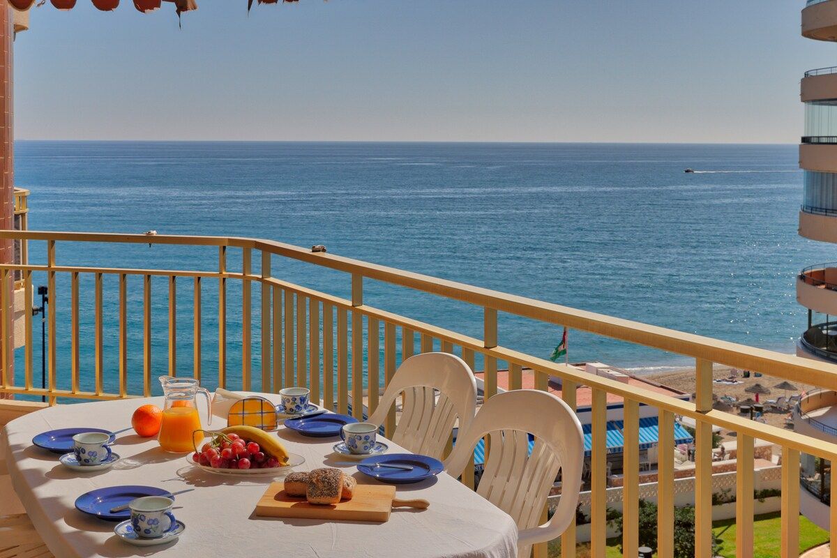 Un balcón con mesa listo para el desayuno, con vistas al mar.