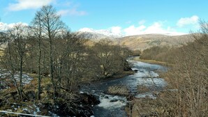 Une rivière qui traverse une vallée, avec des montagnes enneigées en arrière-plan.