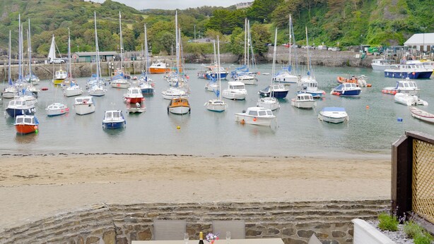 A patio with a table and chairs overlooking a marina with various boats. - 3 bedroom accommodation in Ilfracombe (Ilfracombe)