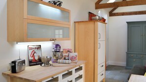 A kitchen with wooden cabinets, a mixer, and a vintage radio.