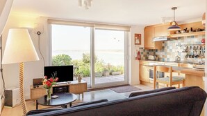 Un soggiorno moderno con un divano, una TV e un'area pranzo con tavolo e sedie.