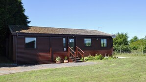 En envåningsbyggnad i trä med en veranda, en liten trappa och en skylt med siffran 46.
