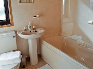 Une salle de bain avec des toilettes, un lavabo et une baignoire.