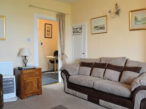 A living room with a sofa, a table, a lamp, and a radiator. - 3 bedroom accommodation in Burnmouth, near Eyemouth (Burnmouth, near Eyemouth)