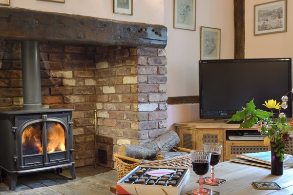 Warm and welcoming inglenook fireplace with wood burner | Henley Bridge Holiday Cottage, Ashburnham, near Battle