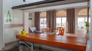 Une cuisine dotée d’un plan de travail en bois, d’un évier et d’un coin repas avec des chaises et une table.