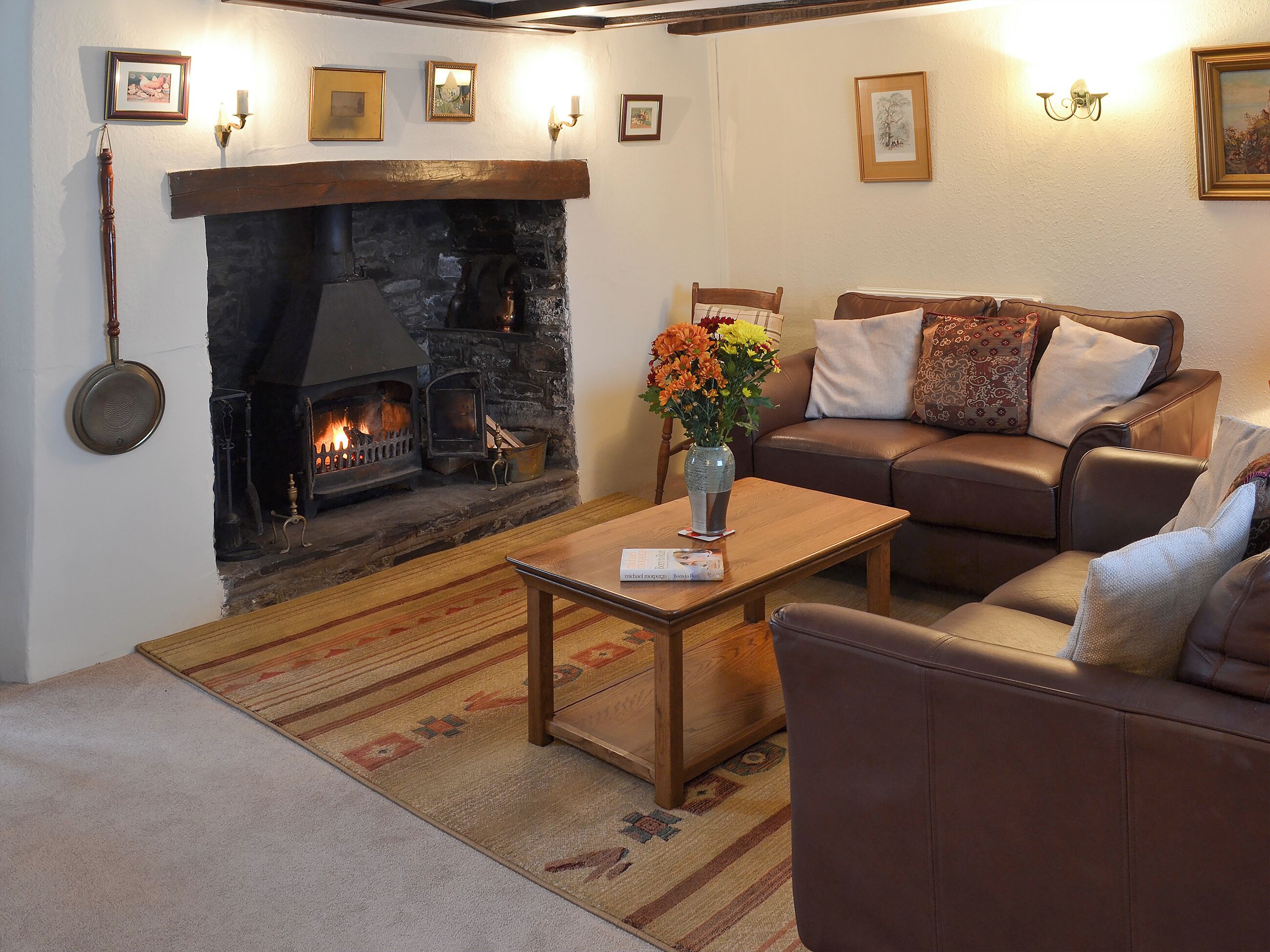 A cozy living room with a fireplace, a sofa, a coffee table, and a rug.