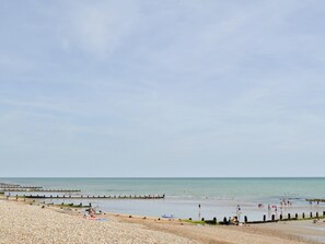 A pebbled beach with a wooden pier extending into calm waters. - 1 bedroom accommodation in Felpham, near Bognor Regis (Felpham, near Bognor Regis)