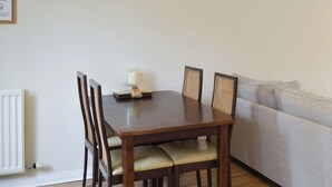 A dining table with four chairs, a candle, and a small decorative item on the table. - 2 bedroom accommodation in Embleton, near Alnwick (Embleton, near Alnwick)