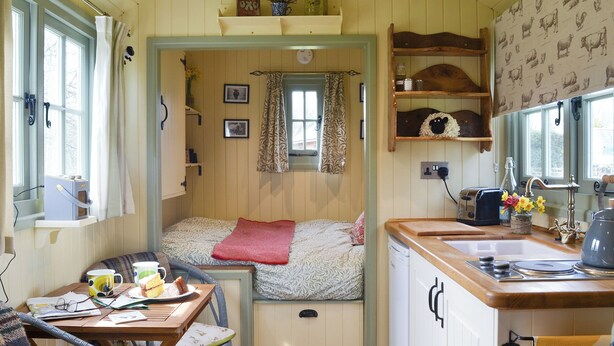 A compact kitchen with a bed, a dining area, and a small window. - 1 bedroom accommodation in Dippertown, near Tavistock (Dippertown, near Tavistock)
