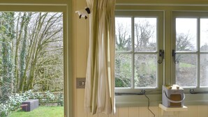A room with a window, a small table with a cup, and a chair. - 1 bedroom accommodation in Dippertown, near Tavistock (Dippertown, near Tavistock)