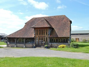 A building with a sloped roof, wooden entrance, and large windows. - 3 bedroom accommodation in Smarden, near Ashford (Smarden, near Ashford)