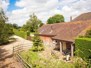 A brick house with a tiled roof, a small porch, and a barbecue area. - 2 bedroom accommodation in Berrow, near Malvern (Berrow, near Malvern)