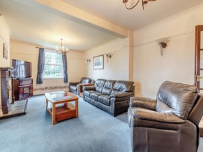 A living room with a sofa set, a coffee table, a television, and a fireplace.