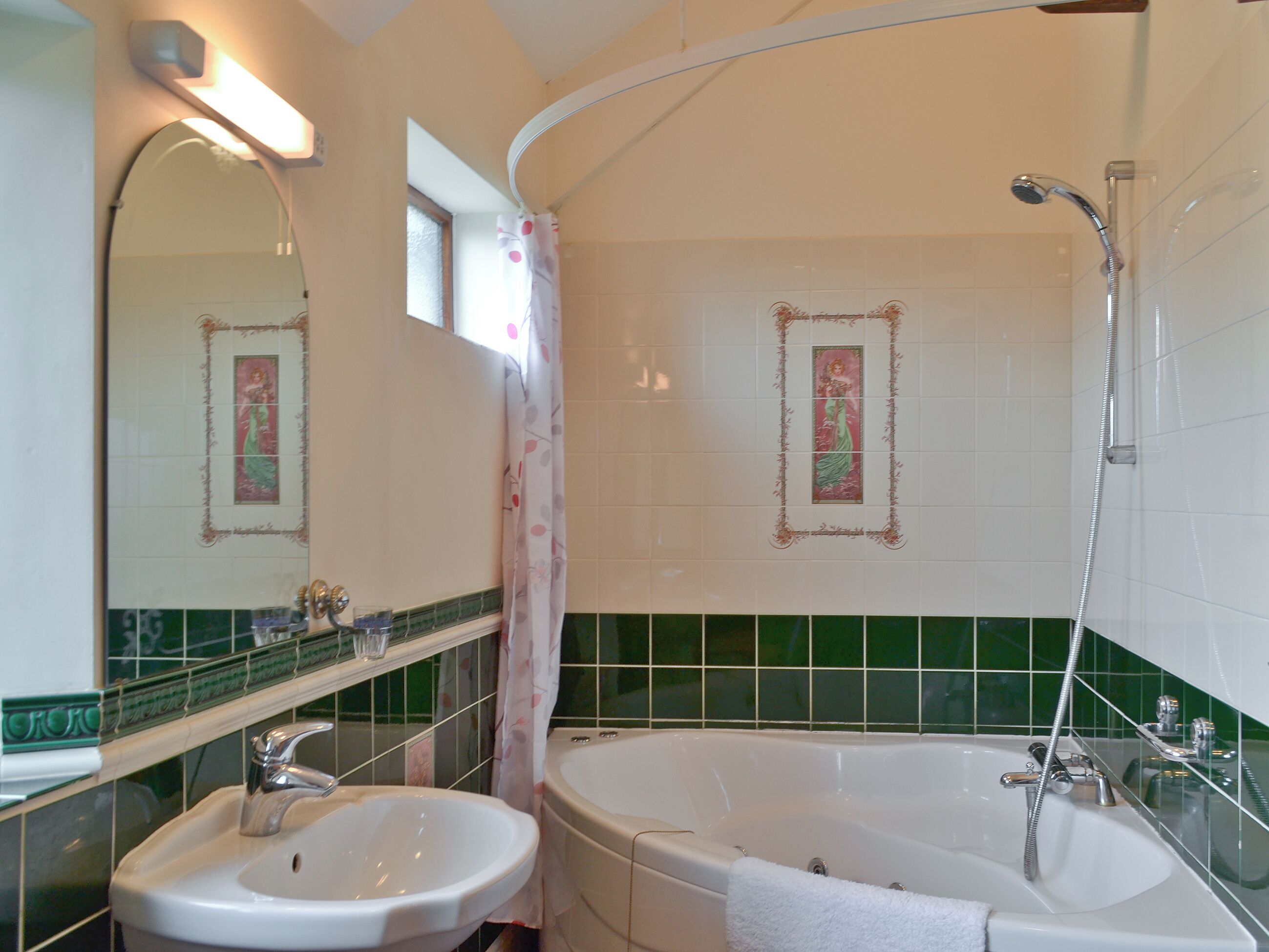 Une salle de bain équipée d’un lavabo, d’un miroir, d’une douche et d’une baignoire.