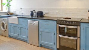 Una cucina moderna con mobili azzurri, lavastoviglie, piano cottura e tostapane.