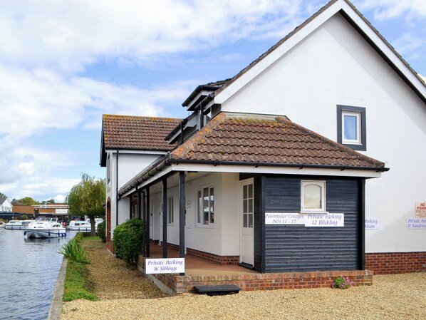 A building with a tiled roof, a covered porch, and a sign indicating private parking for 16 Siblings.