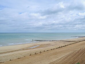 A wide sandy beach with a wooden jetty extending into the water. - 4 bedroom accommodation in Bacton (Bacton)