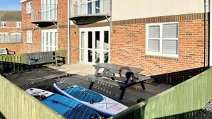Un immeuble résidentiel à la façade en briques, doté d’un balcon et d’un espace piscine avec deux toboggans aquatiques bleus.