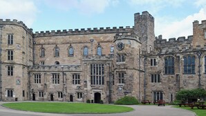 A historic stone building with large windows and a central clock tower. - The Cottage at Wilson House (Barningham, near Richmond)
