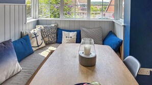 Un coin salon confortable avec une table en bois, un panier de fruits et une bougie.