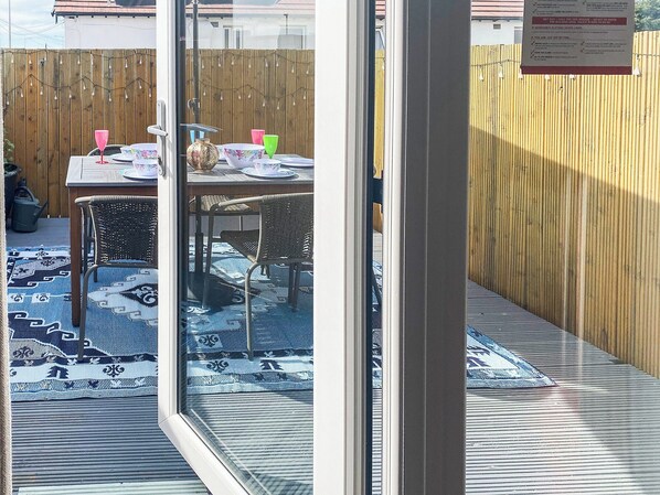 A patio area with a table, chairs, and a decorative rug.