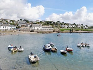 A coastal area with several boats docked near a building labeled "Idle Rocks Hotel".
