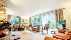 A spacious living room with a large window, a fireplace, and a television. - 4 bedroom accommodation in South Tehidy, near Portreath (South Tehidy, near Portreath)