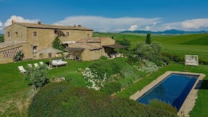 A stone villa with a swimming pool, surrounded by lush greenery and a clear sky. - VILLA MERAVIGLIOSA - Six Bedroom Villa, Sleeps 12 (Pienza)