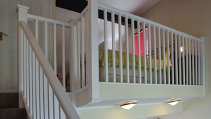 Una escalera con barandillas blancas y un aplique en la parte superior.