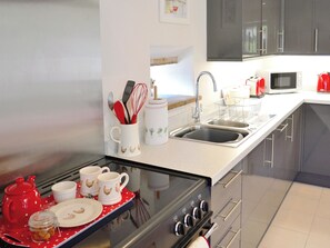 A modern kitchen with stainless steel appliances, a double sink, and a microwave. - 2 bedroom accommodation in Hartland, near Bideford (Hartland, near Bideford)