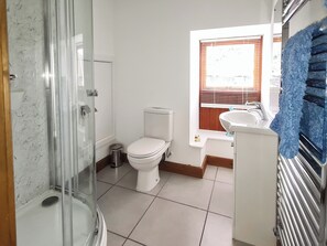 A bathroom with a glass shower enclosure, a toilet, a sink, and a window with blinds. - 2 bedroom accommodation in Hartland, near Bideford (Hartland, near Bideford)