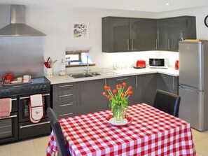 Cocina compacta con estufa, horno, microondas y refrigerador.