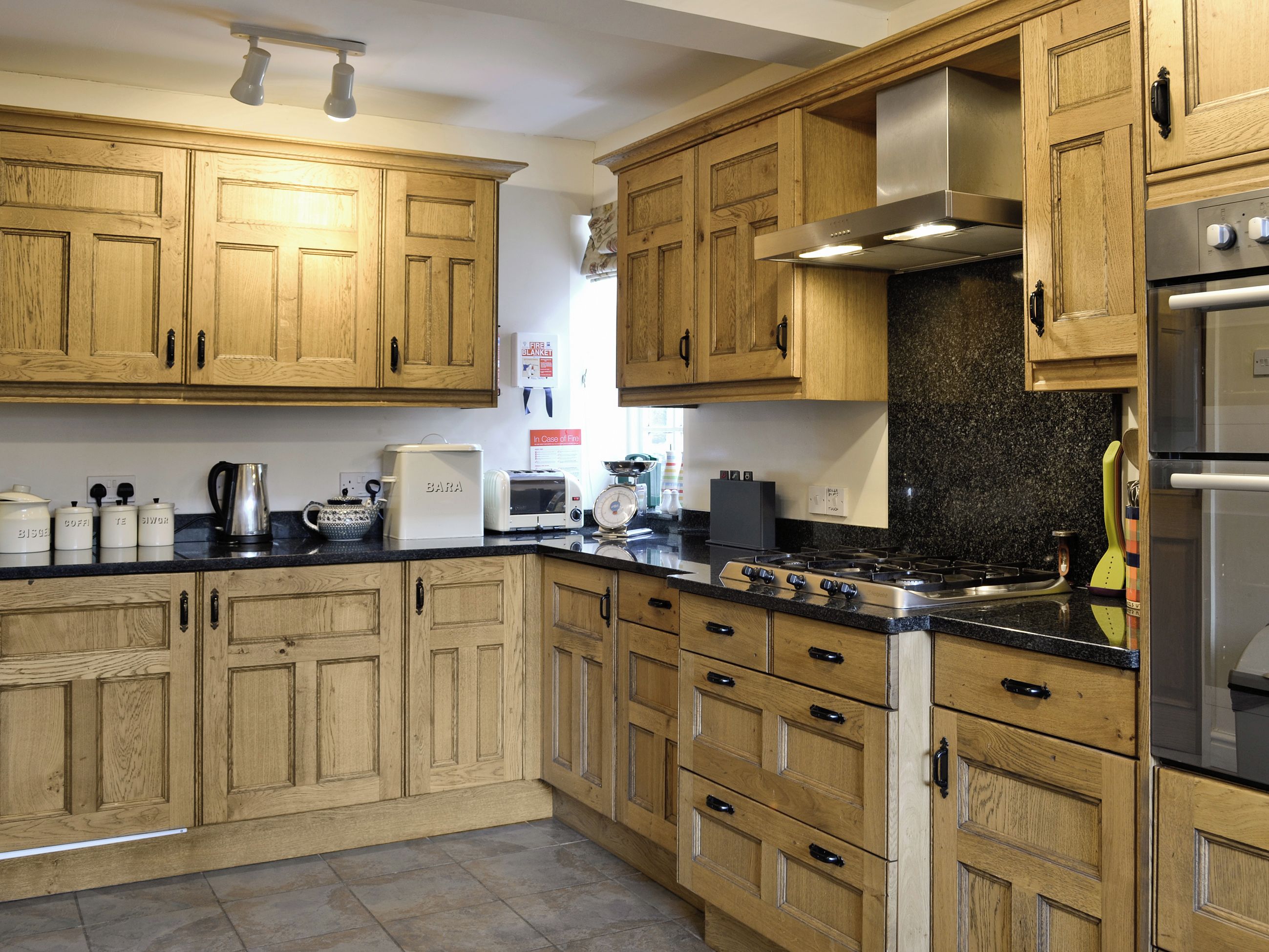 A kitchen with wooden cabinets, a gas stove, a toaster, and a coffee maker.