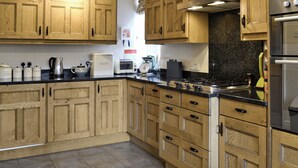 A kitchen with wooden cabinets, a gas stove, a toaster, and a coffee maker.