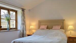 A neatly made bed with two pillows, a bedside lamp, and a nightstand. - 1 bedroom accommodation in Swerford, near Chipping Norton (Swerford, near Chipping Norton)