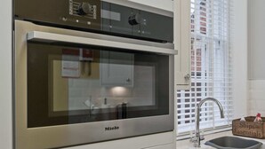 Une cuisine équipée d’un four encastré et d’un évier.