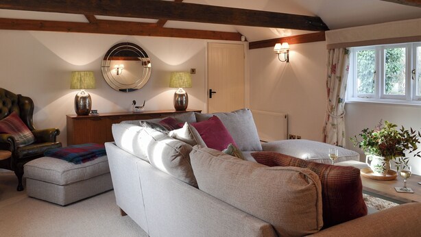 A cozy living room with a sofa set, a mirror, two lamps, and a window with curtains. - Maplehurst Barn Stables (Staplehurst, near Maidstone)