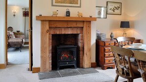 A cozy living room with a fireplace, wooden furniture, and artwork on the walls. - Lakes, mountains or beaches - how about the best of all three. (Bigrigg, near Egremont)